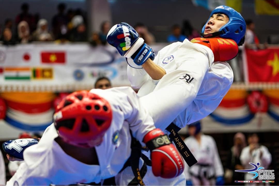 Head coach Seylva and a Taiwanese opponent in a close exchange during a sparring bout at the PTITC 2025 international Taekwon-Do tournament.